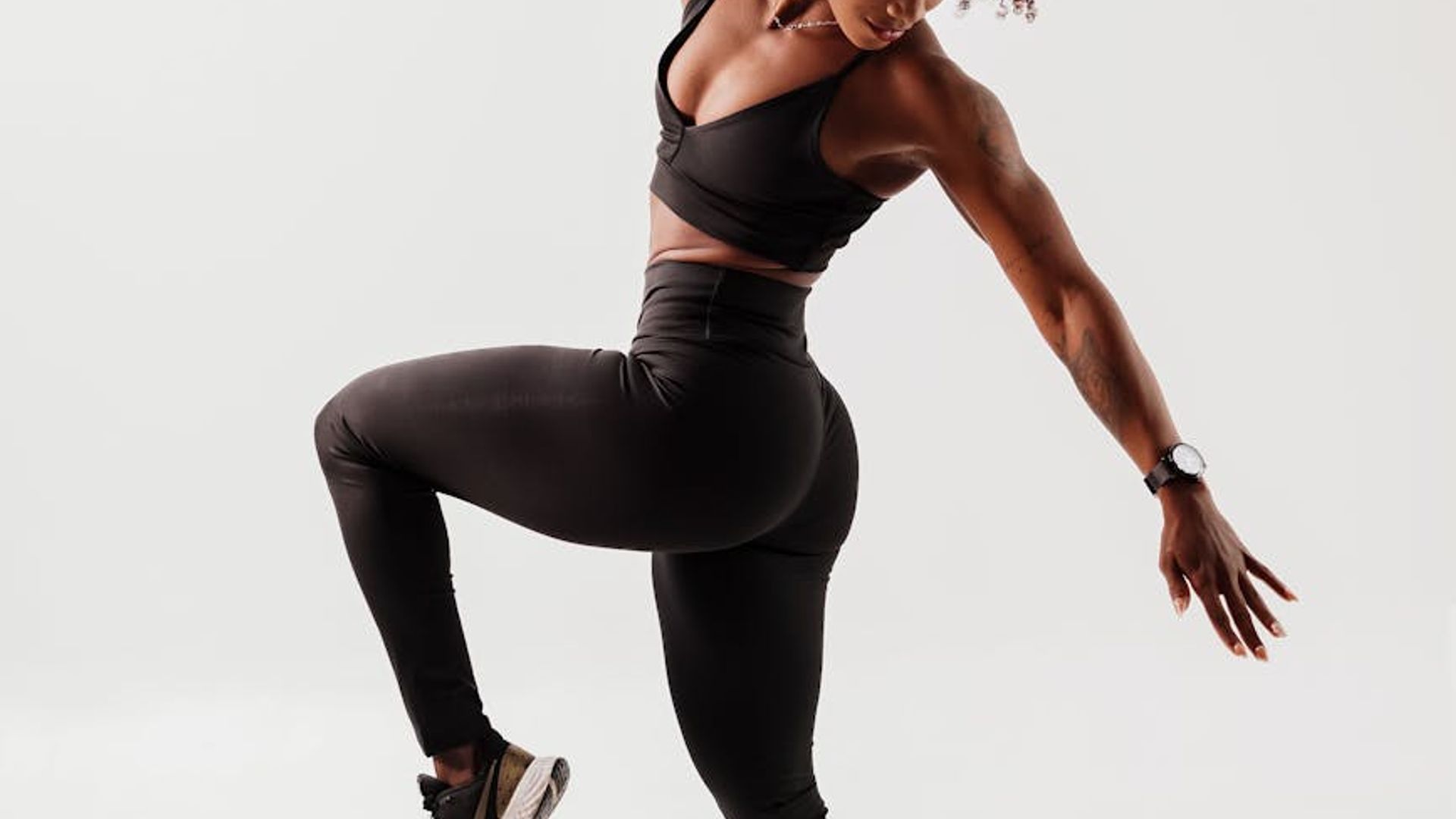 A dynamic athlete moving in a dark minimalist studio space