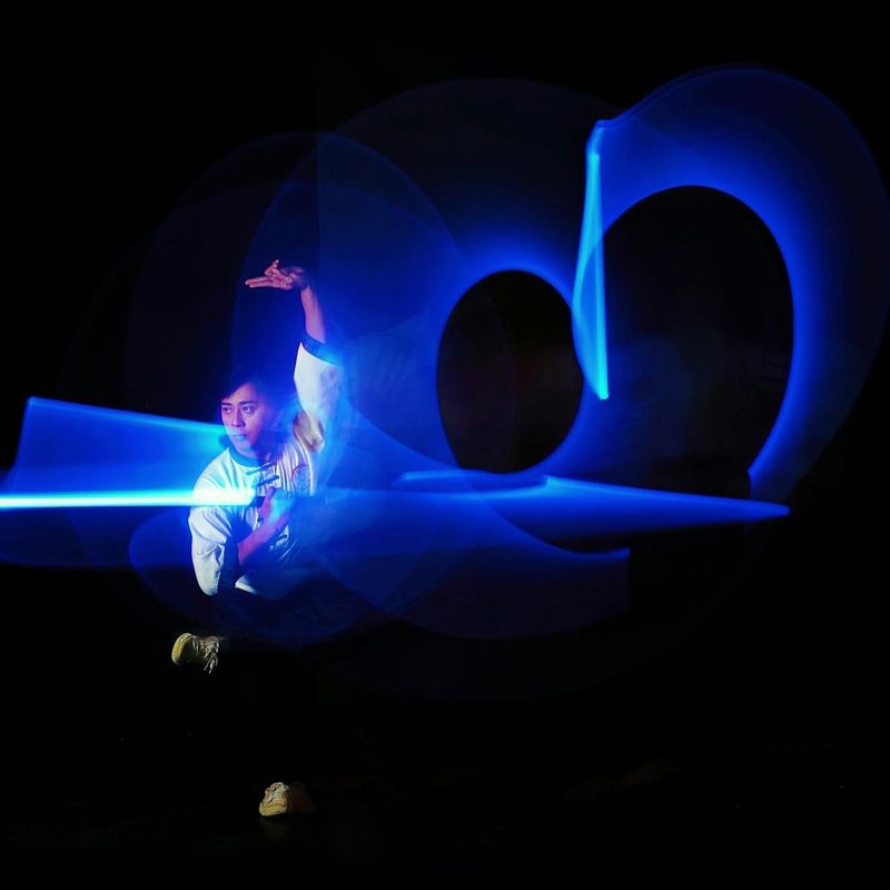 Person doing dynamic movements in a dark blue lit room